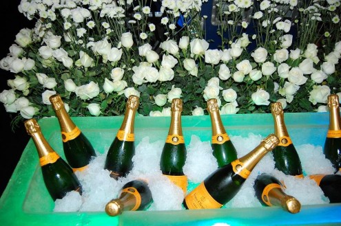 Inconfundíveis e caras garrafas de champanhe Veuve Clicquot, reconhecidas pelo distinto rótulo laranja, foram espalhadas pelos salões da festa