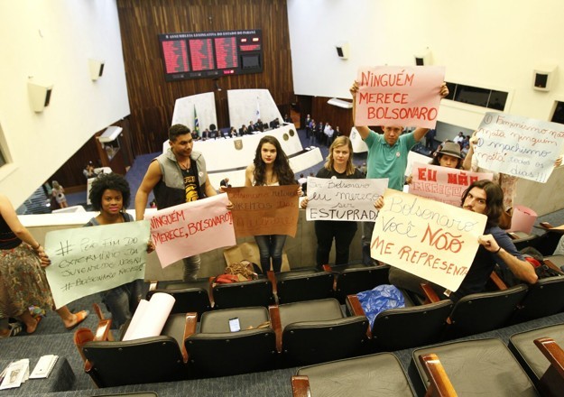 Grupo de jovens exibe cartazes contra Jair Bolsonaro